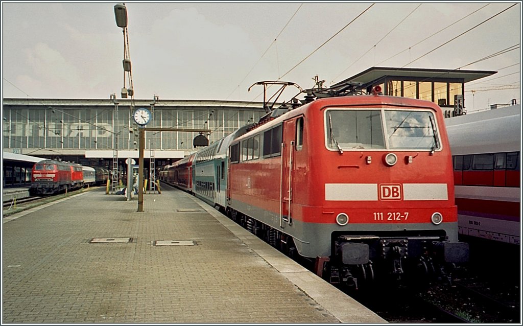 Eine Archiv-Aufnahme von 2004: Die 111 212-7 in Mnchen.
Interessanter als die neu gestrichene Lok sind Details rund ums Motiv. 
